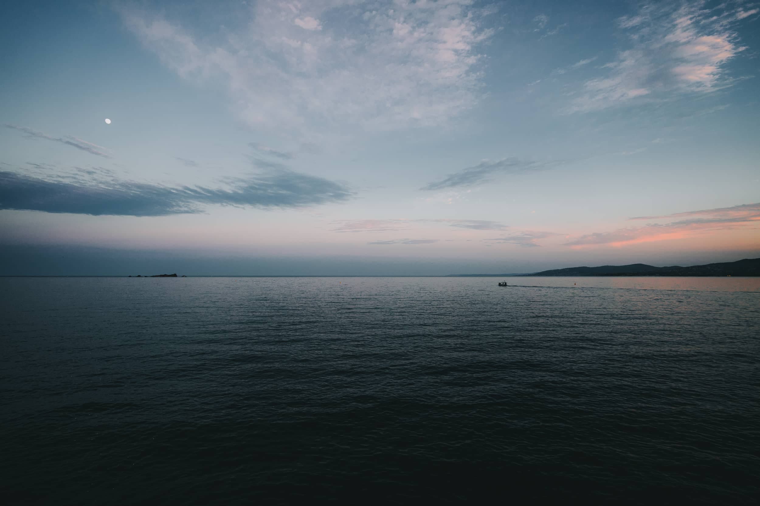 Mer calme au crépuscule, horizon rose et bleu